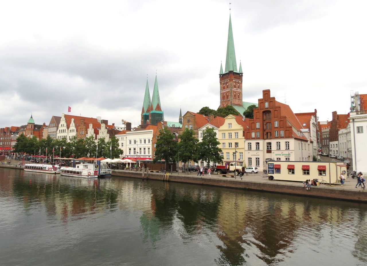 Picturesque waterfront view of historic buildings in Lübeck, Germany, reflecting in a canal.