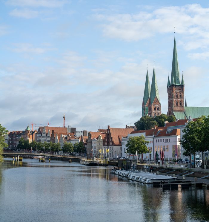 Beautiful view of Lübeck, Germany's waterfront with iconic church spires and historic buildings.